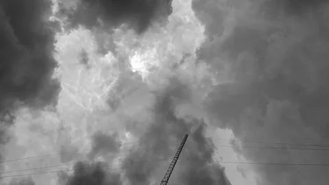 A dark, cloudy gray sky with a cellular signal tower. Stock Photos