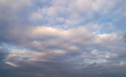 Dark cloudy sky with red reflections at sunset. Stock Photos
