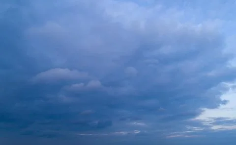 Dark cloudy sky with red reflections at sunset. Stock Photos