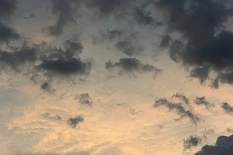 Dark cloudy sky with sunset light and scattered clouds Stock Photos