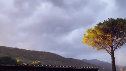 Dark cloudy sky with sunset rays and rainbow after strong thunderstorm, dramatic Stock Footage 269691520