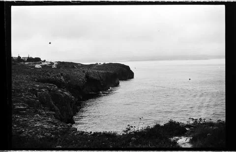 Dark Coastal Cliffs Framing a Calm Sea Inlet Stock Photos