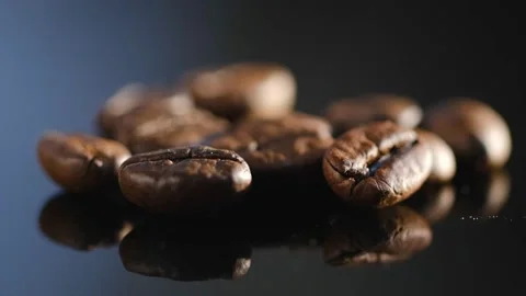 Dark coffee beans. Rotation on a black mirror surface. Coffee beans. Close up Stock Footage 168982509