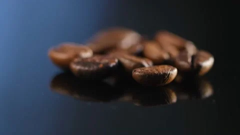 Dark coffee beans. Rotation on a black mirror surface. Coffee beans. Close up Stock Footage 169440881