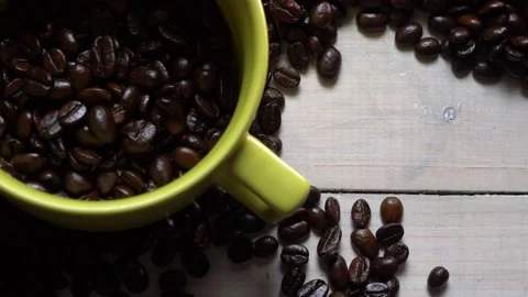 Dark coffee beans with yellow mug on wooden background Stock Footage 160254411