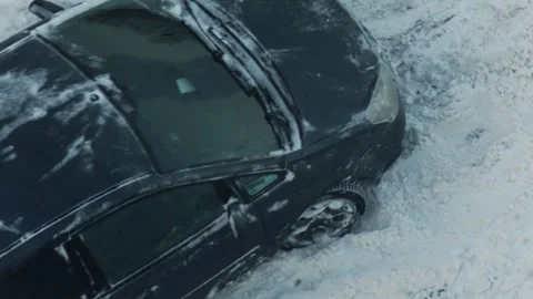 Dark color car stuck in deep winter snow on roadside after heavy snowfall during Stock Footage 344095750