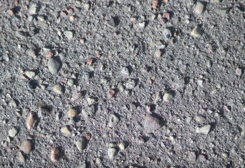 Dark colored asphalt background mixed with pebbles. Asphalt texture Stock Photos