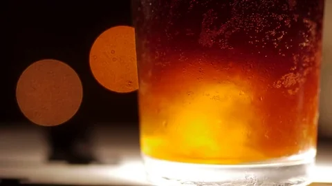 Dark colored cocktail with ice. Closeup shot on a blurry background Stock Footage 73997656