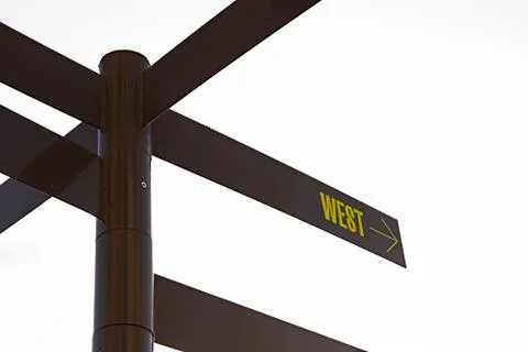 Dark coloured multidirectional signpost with applied direction to WEST text Foto stock