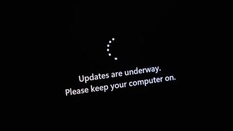A dark computer screen shows Updates are underway. Please keep your compute.. Stock Footage 314389033