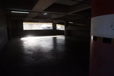 Dark Concrete Parking Structure Interior With Natural Light Foto stock