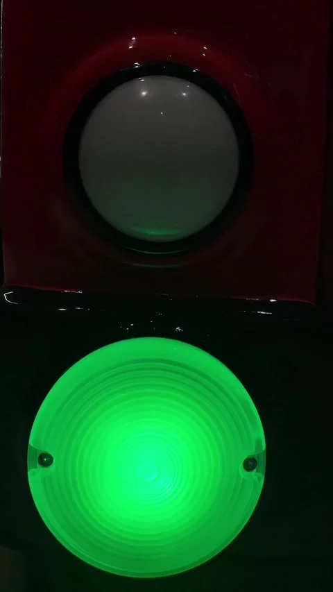 Dark control panel with glowing green button and reflective bezel Stock Footage 347333491