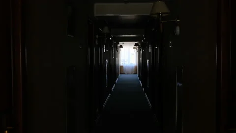 Dark corridor in hotel, at the end of which there is window and bright light Stock-Footage 153246924
