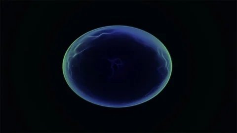 In the dark cosmos, a blue planet glows like a sphere, illuminated by a distant  Stock Footage 296871317