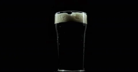 Dark craft beer crafting in a private brewery for the festival is poured into a Stock Footage 107765077