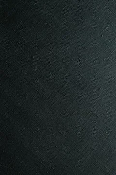 Dark creative background: black primed linen canvas, uneven lighting, color t Stock Photos