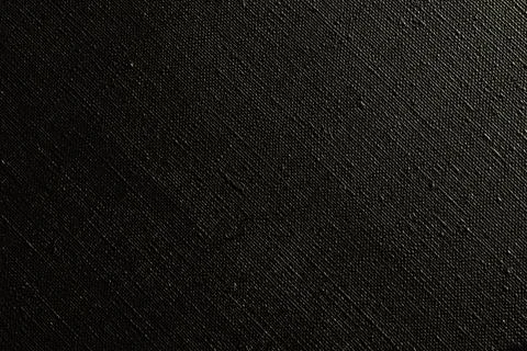 Dark creative background: black primed linen canvas, uneven lighting, color t Stock Photos