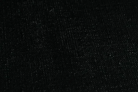 Dark creative background: black primed linen canvas, uneven lighting, toning Stock Photos