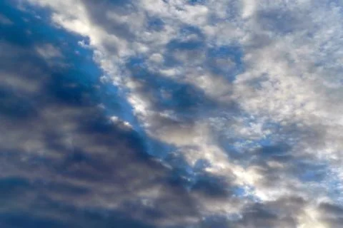 Dark Cumulus and light feathery clouds on the blue sky. Stock Photos