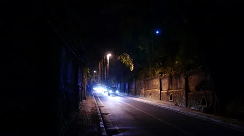 Dark cutting road single lamp in middle, brightly illuminated with car headlight 스톡 동영상 52534815
