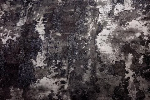 Dark decaying wall surface with textured patches, erosion marks, and black Stock Photos