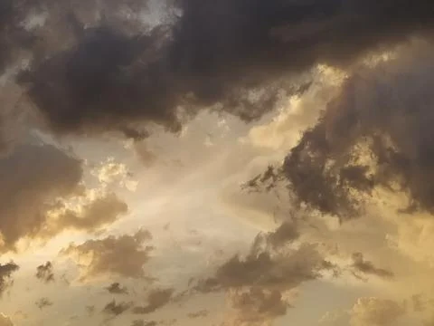 Dark dramatic clouds with golden sunset light. Moody atmospheric sky background 스톡 사진