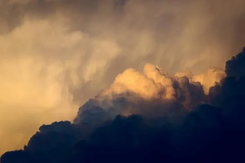 Dark, dramatic nimbus clouds at sunset, lit by the last rays of sunlight befo Stock Photos