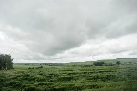 Dark dramatic rainy sky clouds over agricultural rural landscape Stock Photos