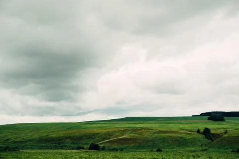 Dark dramatic rainy sky clouds over agricultural rural landscape Stock Photos