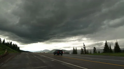 Dark dramatic storm moving over road on mountain summit in Wyoming Video stock 132682775