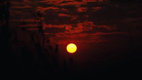Dark dramatic sunset with glowing sun and clouds Vidéo 326989784