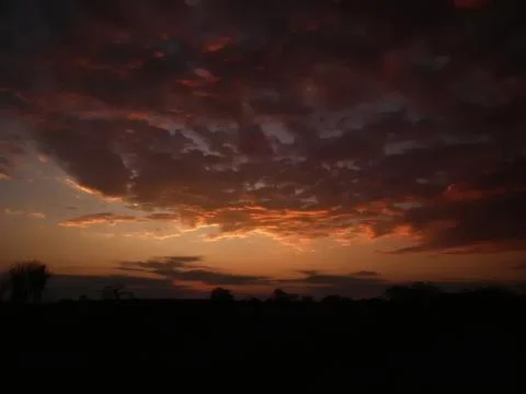 Dark dramatic sunset sky with colorful clouds over landscape 写真素材