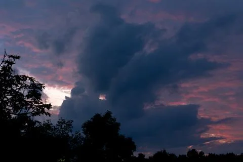 Dark dramatic sunset sky with heavy cloud silhouette and pink twilight glow Photos
