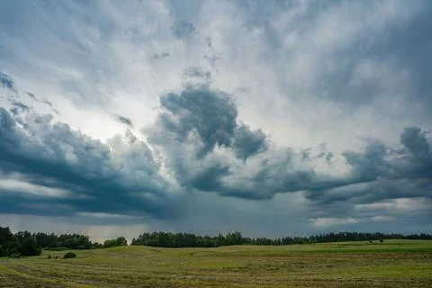 Dark dramatic thunderstorm clouds over rural landscape with approaching rain 写真素材