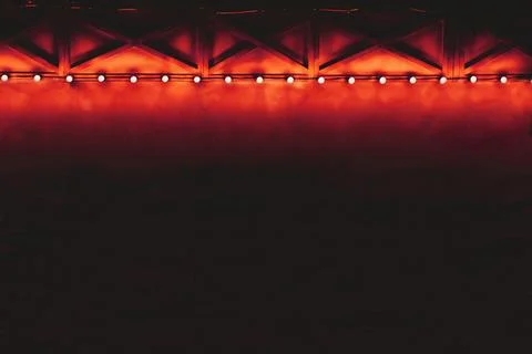 Dark draped decorated wall with red orange backlight Stock Photos