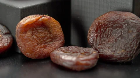 Dark dried apricots close-up on a black background. Stockbeeldmateriaal 150712847