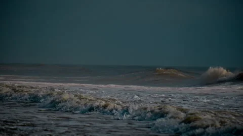 Dark During stormy and windy day big ocean waves roll onto the sandy shore Stock Footage 306891498