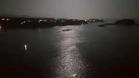 Dark, elevated perspective of a dramatic ocean cove at night Stock Footage 323411822