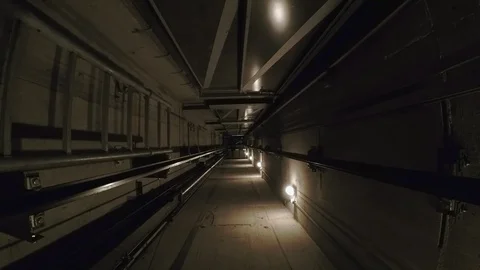 In a dark elevator shaft, the cabin moves down.  Stock-Footage 88415265