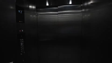 A dark, empty elevator with a blue and white sign on the wall Stock Footage 297860746