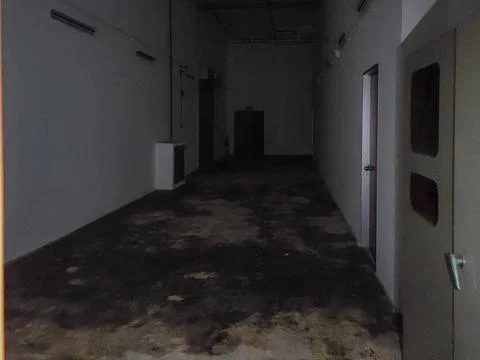 Dark, empty hallway with worn floor and dim lighting Stock Photos