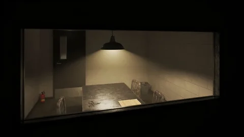 Dark, empty interrogation room seen through one-way mirror Stock Footage