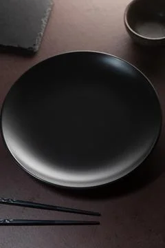 Dark empty plate without food and chopsticks, top view. Stock Photos