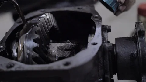 Dark engine oil is poured into the open brewed gearbox Stock Footage 127444387
