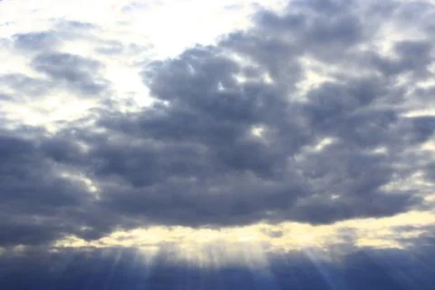 Dark evening clouds and beams of sun Stock Photos