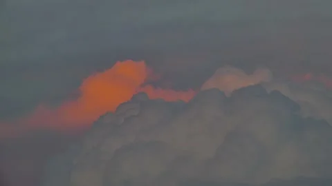 Dark, evening clouds slowly float across the sky, half illuminated Stock Footage 157072694