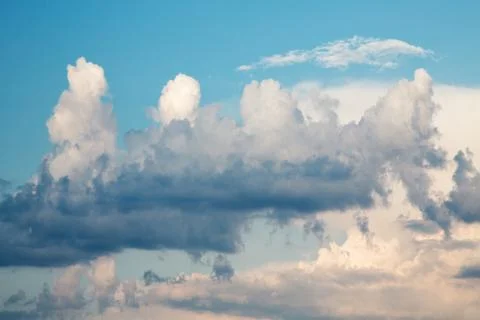 Dark evening cumulus clouds in the setting sun Stock Photos