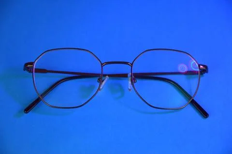 Dark eyeglasses on a deep blue background Stock Photos