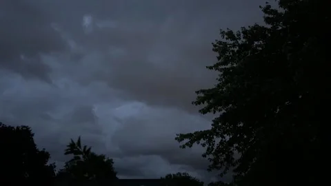 Dark fast moving storm clouds with lightning flashes at night Stock Footage 336807355