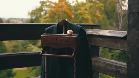 Dark fiance suit jacket on designed wooden hanger on balcony 스톡 동영상 150908816